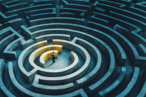 A figure stands in a maze, illuminated by warm light, symbolizing introspection and decision-making.

