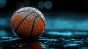 A close-up of a wet basketball on a blue background, emphasizing texture and dynamic lighting.

