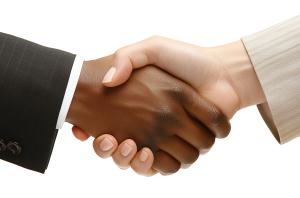 A man and woman shaking hands, symbolizing agreement and collaboration in a professional context.