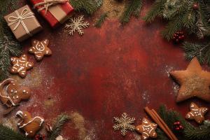 A rustic Christmas background featuring gingerbread cookies and festive decorations.