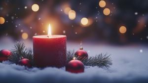 A warm Christmas candle surrounded by ornaments and snow, creating a festive winter atmosphere.