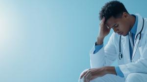 Download image depicting a stressed medical professional, symbolizing the challenges faced in healthcare.