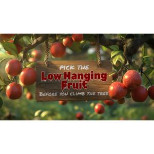 A wooden sign hangs among ripe red apples, symbolizing the business idiom &quot;low hanging fruit.&quot;