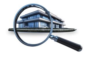 This image illustrates a company audit with a magnifying glass focused on a modern building.