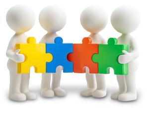 Colorful teamwork puzzle clipart with four figures holding pieces, perfect for collaboration and team-building presentations.