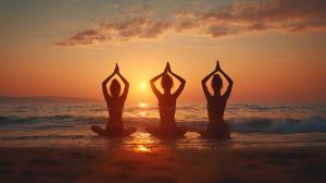 This image shows three individuals practicing yoga at sunset on a beach, symbolizing relaxation and mindfulness.