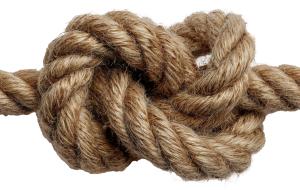 Close-up of a sturdy rope tied in a knot. Perfect for themes of connection, security, teamwork, problem solving, strength, and resilience.