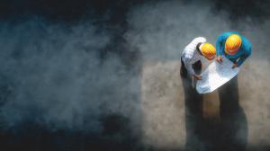  
This background image captures construction planners reviewing blueprints, emphasizing teamwork and project management.

