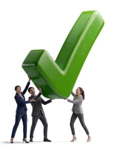 This clipart showcases a checkmark being lifted by a diverse group of professionals, symbolizing teamwork and the successful completion of a task.