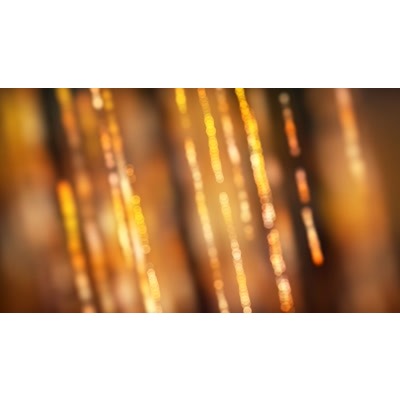 Golden beads falling across a bright surface.